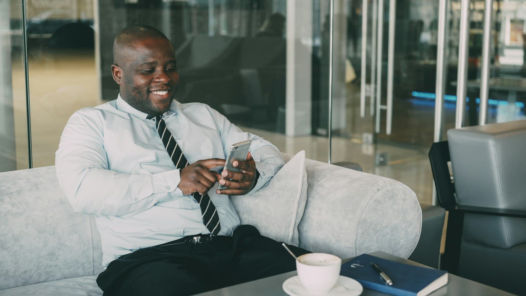 A smiling business owner checking his phone in his office