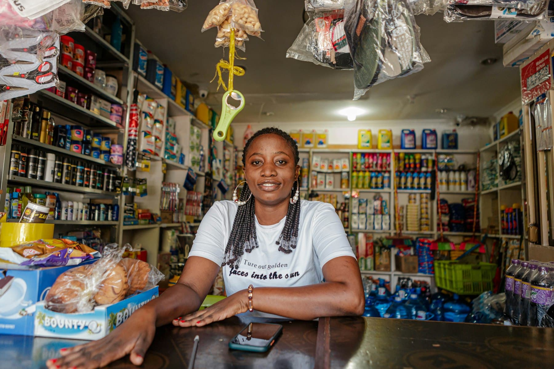 Shop owner at her counter approving on her phone